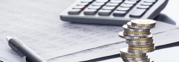 Rechner, Stift und Geldstapel